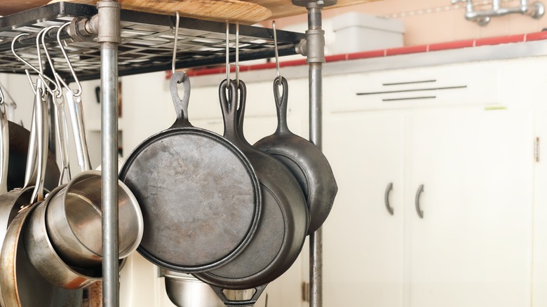 Hanging metal pots and pans in a kitchen.