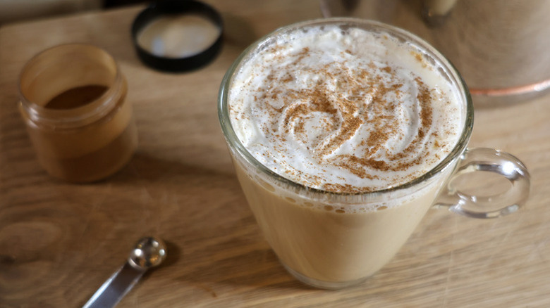 Latte in mug with whipped cream and cinnamon garnish
