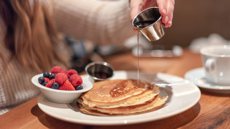 person eating pancakes at restaurant