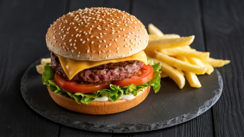 Hamburger and fries on a black plate
