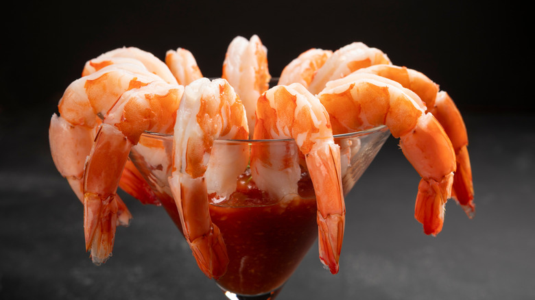 Close up image of a classic shrimp cocktail served in a martini glass with a red sauce