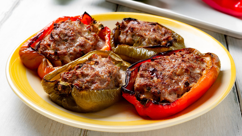 Yellow plate with baked peppers stuffed with ground beef