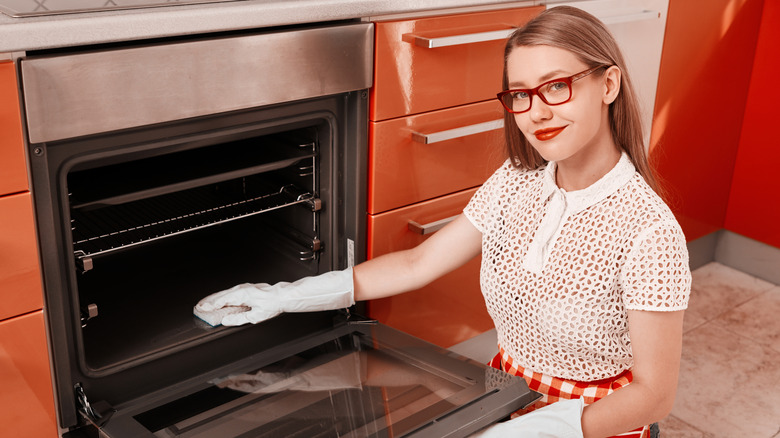 person cleaning vintage oven