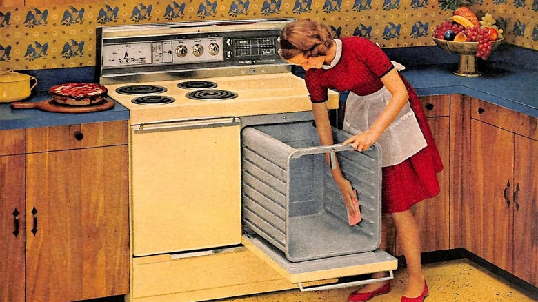 Vintage ad displaying a woman in a red dress cleaning a 1960s Pull 'N Clean oven.