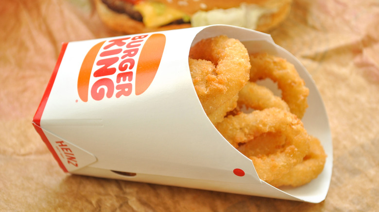 A cardboard container of Burger King onion rings laying on its side