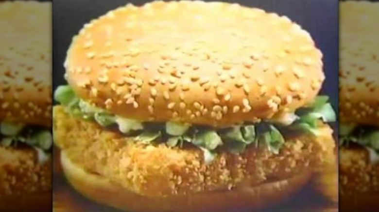 A Burger King Whaler sandwich featuring a square fish patty with lettuce on a sesame seed bun