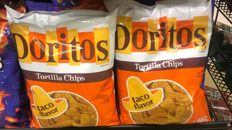 Two bags of taco-flavored Doritos on a grocery store shelf, with retro packaging