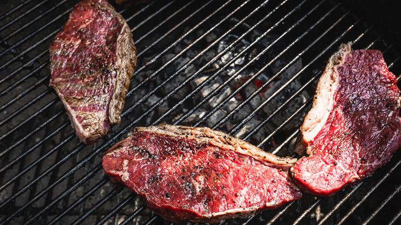 Uncooked picanha steaks on grill, fat crisped up