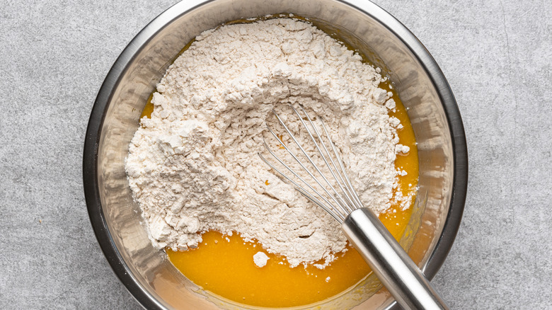 flour and pumpkin puree in a mixing bowl with a whisk