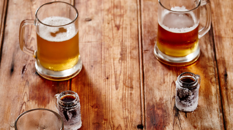 Beer steins and chilled shots of Jägermeister on wooden table