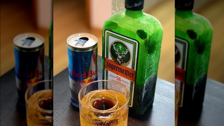 Jäger Bomb with a can of Red Bull and a bottle of Jägermeister in the background