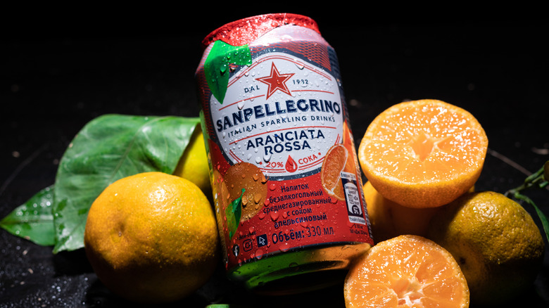 A can of San Pellegrino blood orange among whole and sliced oranges