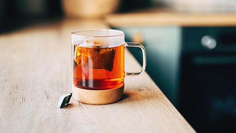 A glass of black tea on a kitchen counter