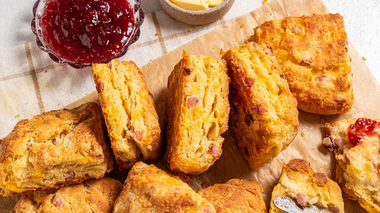 Buttery Ham and Cheese Biscuits on parchment paper with jam