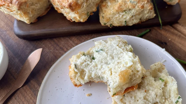 Tender, Fluffy Cream Cheese Cheddar Biscuit with a bite taken out on white plate