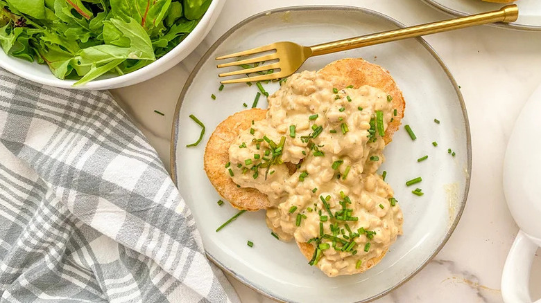 Vegan Biscuits and Tempeh Sausage Gravy on white plate with gold fork
