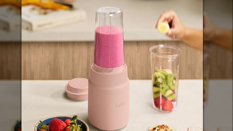 A person adding fruit into a BELLA blender