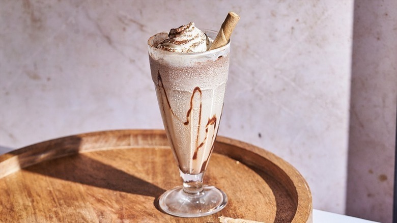 Nutella mudslide cocktail in glass, topped with whipped cream and wafer