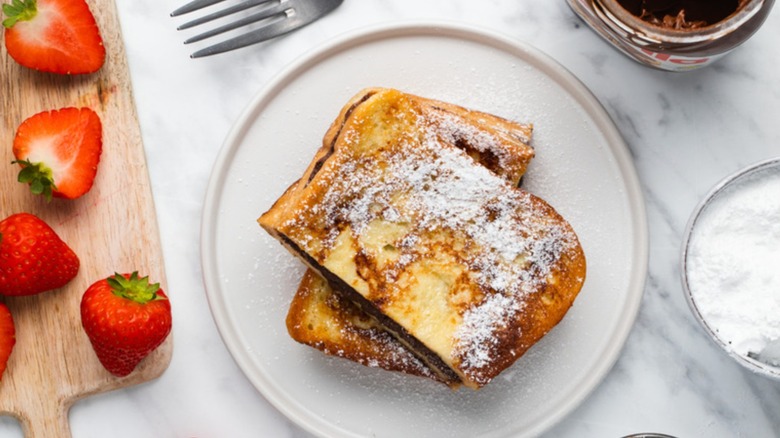 Nutella-stuffed French toast stack on white plate