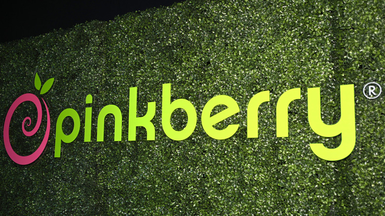 Pinkberry sign on fake grass wall