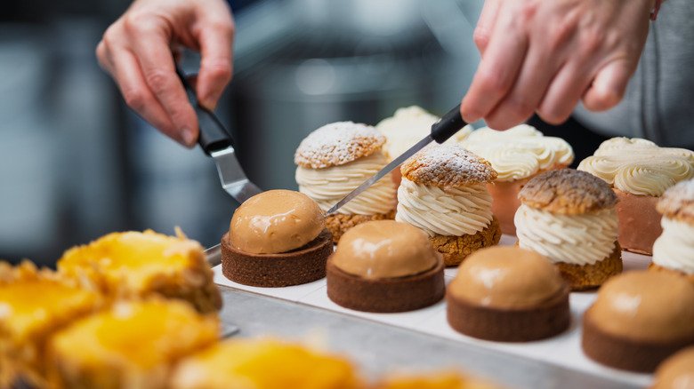 Hands serving pastries with utensils
