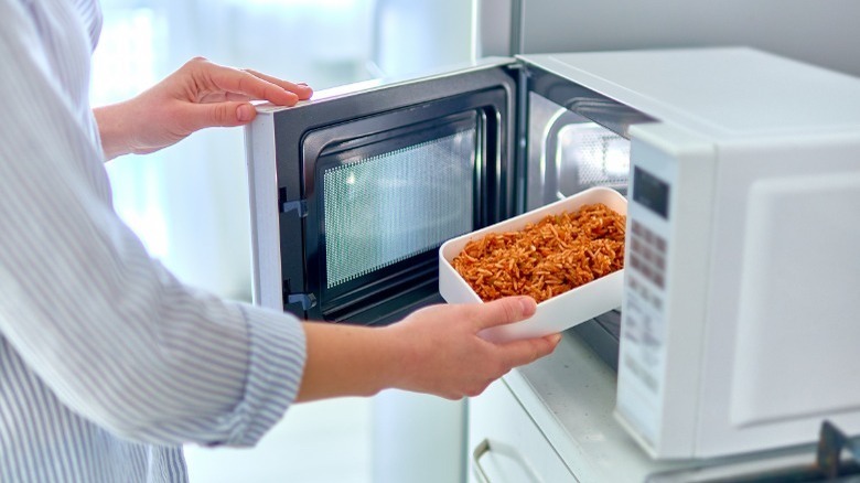 Person warming food in microwave