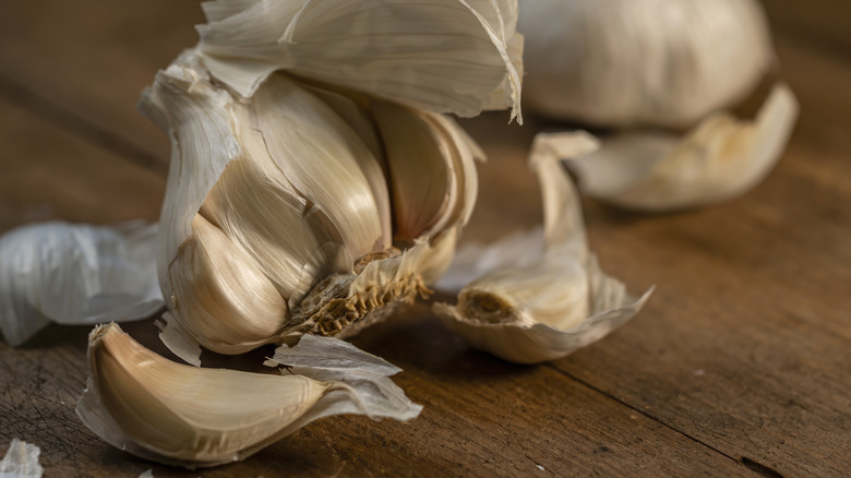 A garlic bulb shown with individual cloves removed, showing their top and bottom ends