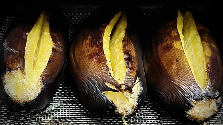 Three roasted bananas on wire mesh tray