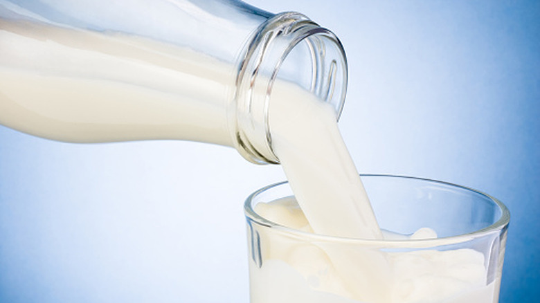 Milk being poured from bottle into glass