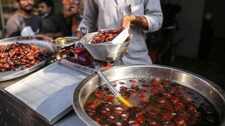 A vats of gulam jamun in a restaurant kitchen