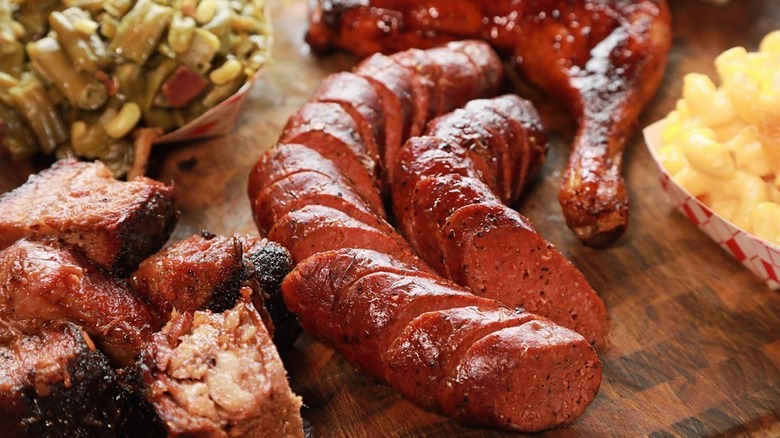 BBQ spread including burnt ends, sausages, and green beans