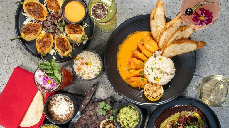 Top view of Mexican dishes with rice and cocktails on table