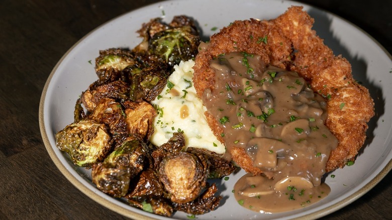 Pork schnitzel with mushroom gravy on plate