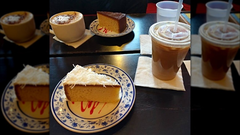 Two pieces of tres leches cake and two coffee drinks on table