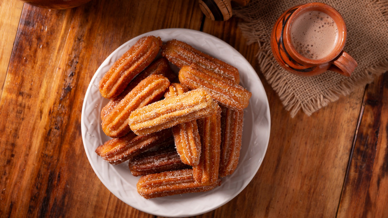 Churros on white plate and coffee drink