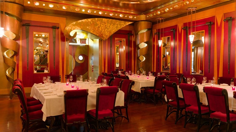 Dining room at Italian Village with red chairs, long tables, and low lighting