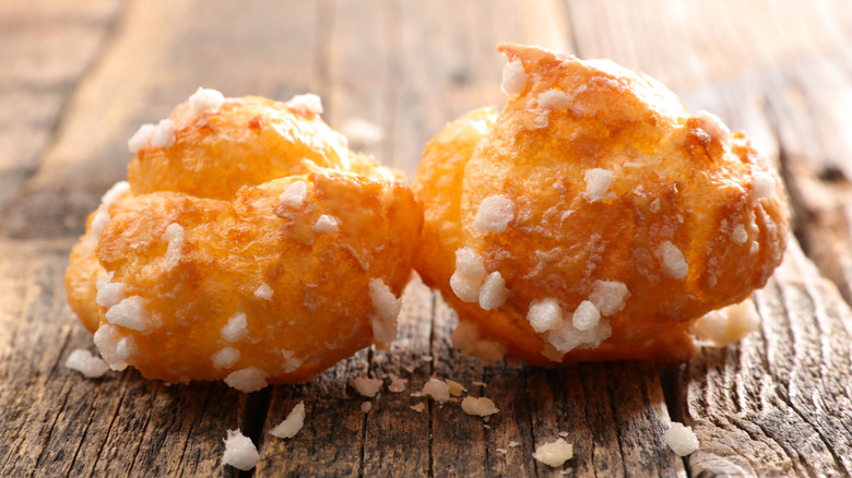 Two chouquettes on wooden surface