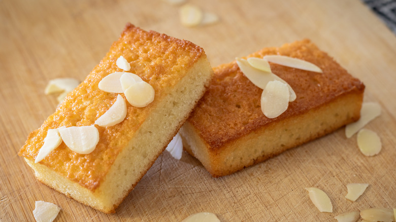 Two pieces of financier cake topped with shaved almonds