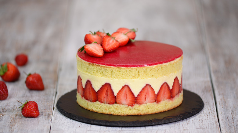 Fraisier cake topped with fresh strawberries and strawberry coulis