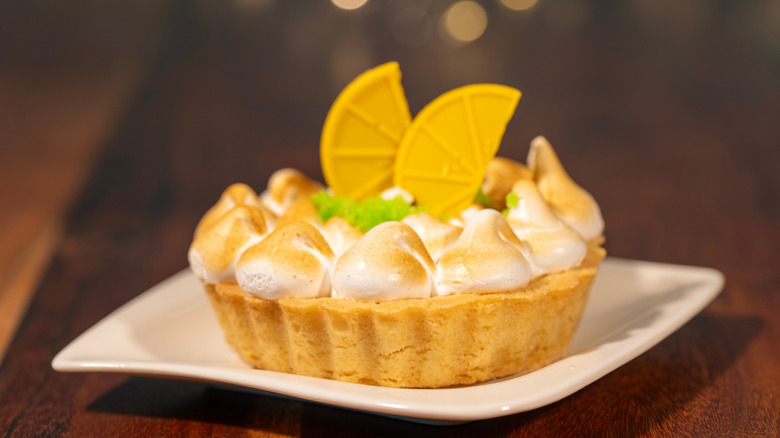 Piece of tarte au citron meringuée on wooden table