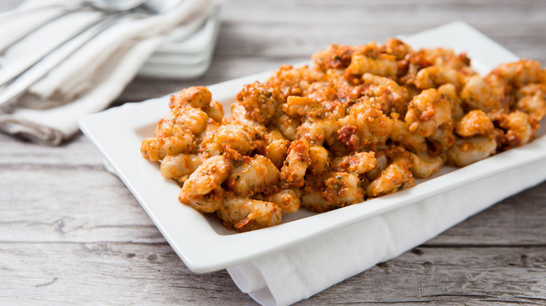 Sun-dried tomato pesto gnocchi on white serving plate