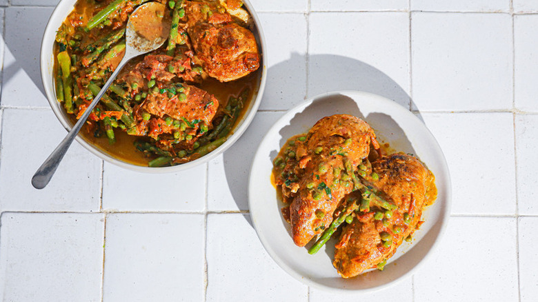 Crockpot sun-dried tomato chicken with tomatoes and asparagus, served onto plate