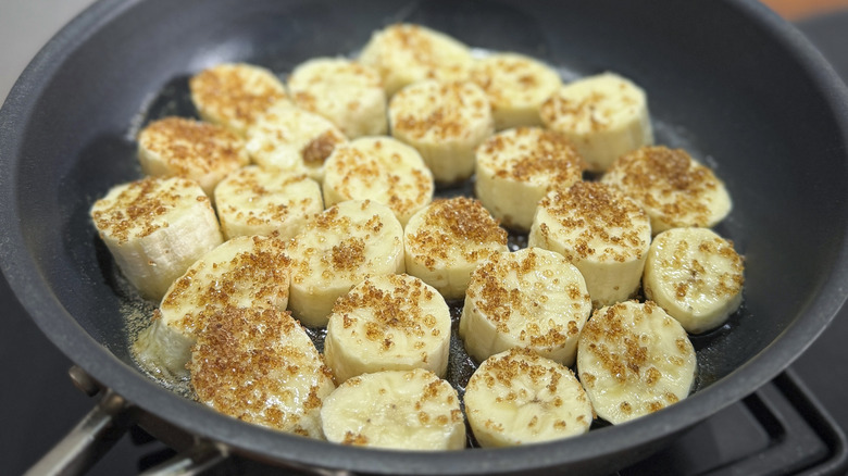 Banana slices sprinkled with sugar in pan