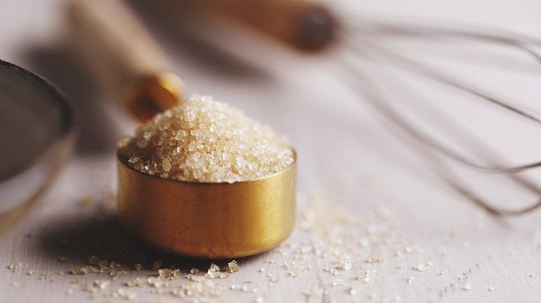 Brown sugar in measuring cup next to whisk