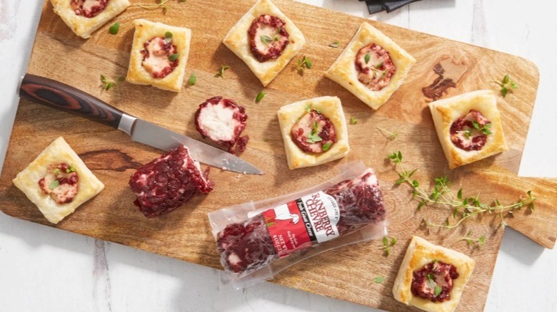 Cutting board with cranberry chèvre, knife, and squares of bread