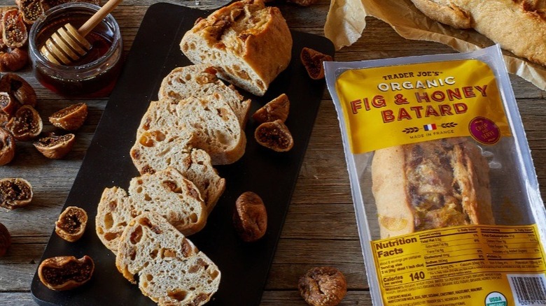 Sliced fig and honey batard on cutting board alongside honey and figs