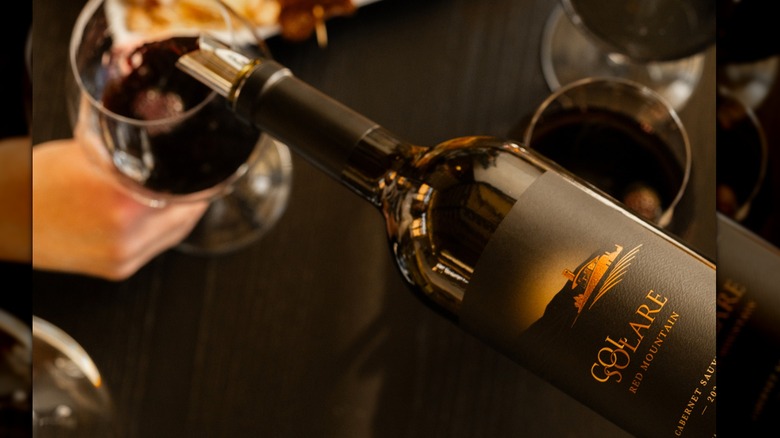 Pouring Col Solare Red Mountain Cabernet Sauvignon into a glass.