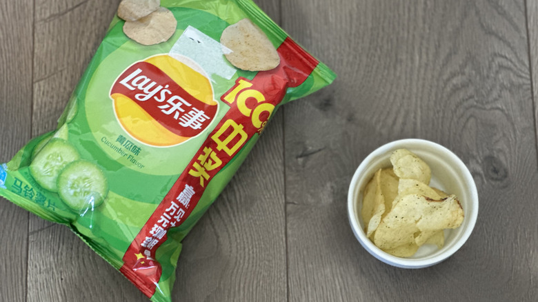 Overhead image of bag of Lay's Cucumber flavored potato chips with small white ramekin filled with chips