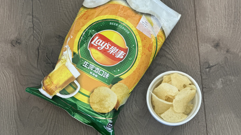 Overhead image of bag of Lay's Beer flavored potato chips with small white ramekin filled with chips
