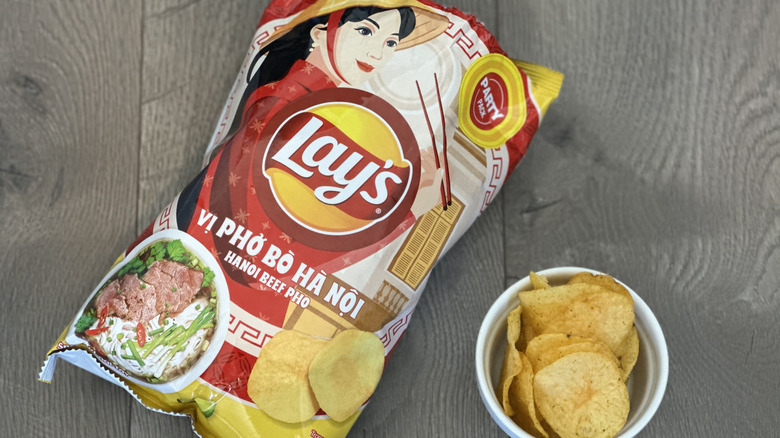 Overhead image of bag of Lay's Hanoi Beef flavored potato chips with small white ramekin filled with chips